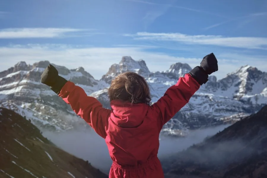 Anonymous kid celebrating success in mountains What Actually Leads To Success?